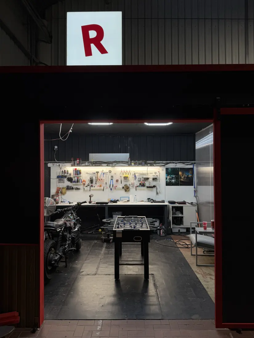 The open door into the garage, workbench lit up inside
