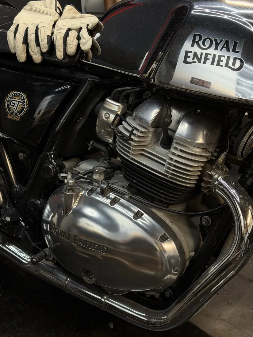 A freshly polished engine cover and exhaust on a Royal Enfield twin