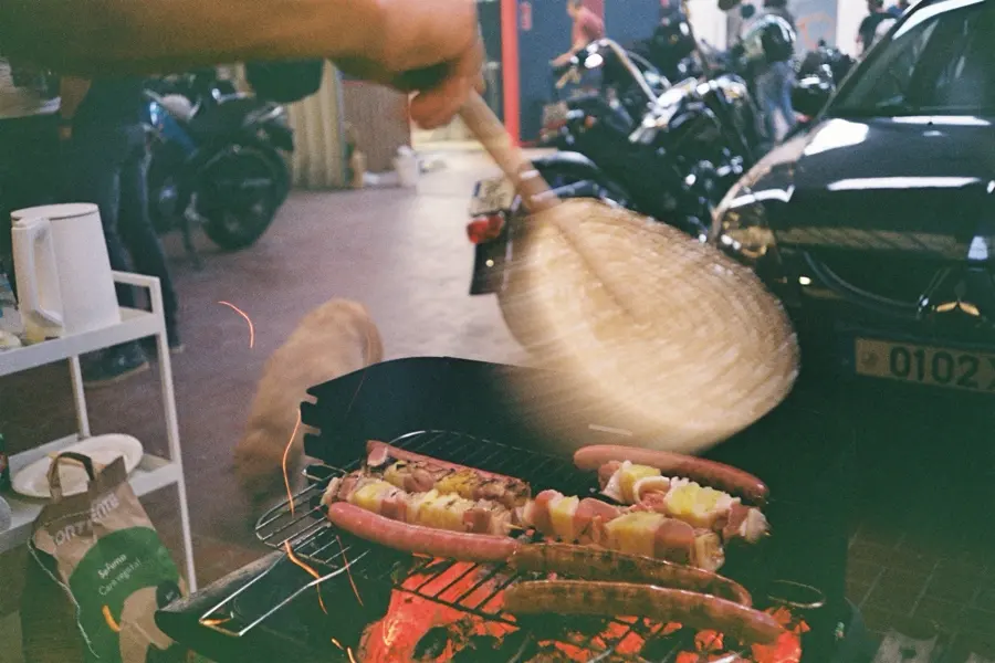 Fanning the grill, sausages and peppers over the coals between the bikes